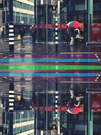 People walking on wet street in city during rainy season