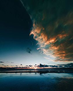 Scenic view of calm lake against cloudy sky