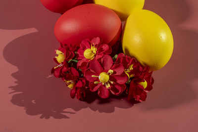 Colorful eggs symbolizing easter on a colorful background and flowers
