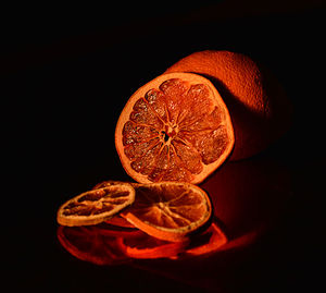 Close-up of orange on table against black background