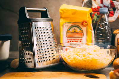 Cheddar cheese grated as close-up shot on an old vintage wooden table