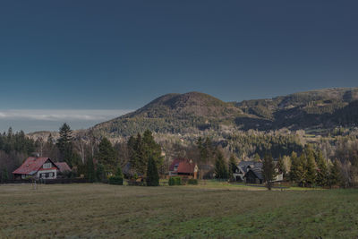 Scenic view of trees and houses against sky