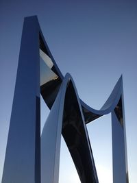 Low angle view of metal structure against blue sky