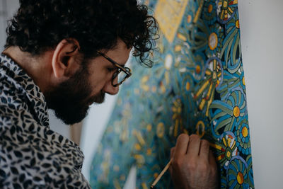 Close-up of man painting on canvas at home