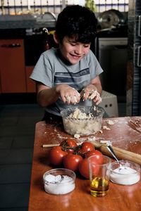 Child preparing pizza dough to make at home