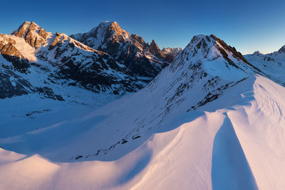 Scenic view of snowcapped mountains against clear sky