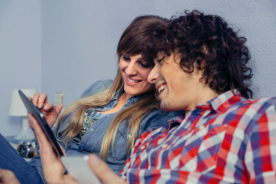 Young woman using phone while sitting on laptop