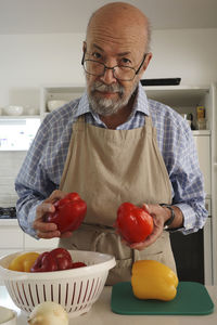 Portrait of senior man holding apple