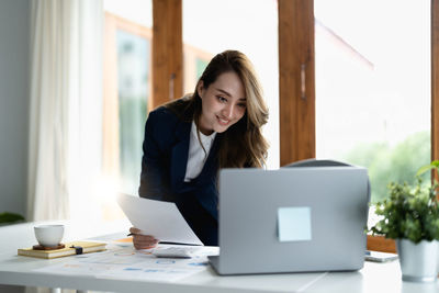 Businesswoman using laptop at office