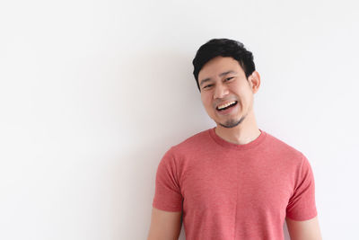 Portrait of smiling young man against white background