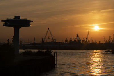 Commercial dock by pier against sky during sunset