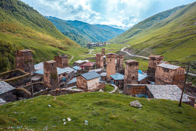 Scenic view of landscape and houses against sky