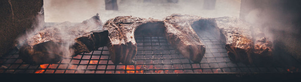 Panoramic shot of meat on barbecue grill