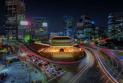 High angle view of illuminated street amidst buildings at night