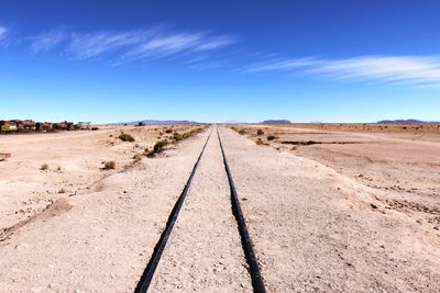 Railroad track against blue sky at salar de uyuni