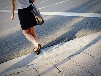 Low section of woman walking on street