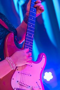 Midsection of woman playing guitar