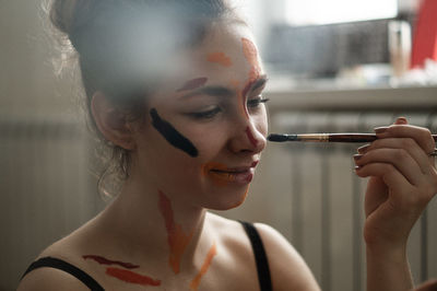 Close-up portrait of young woman with face paint