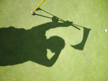 High angle view of golfer shadow on course