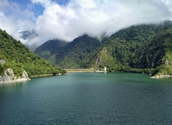 Scenic view of river and mountains against sky