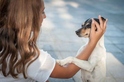  woman petting dog on street