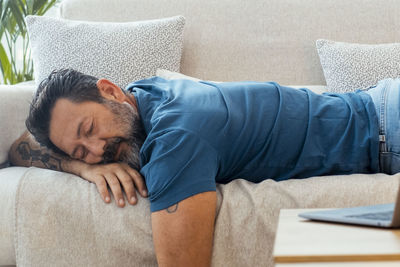 High angle view of man sitting on sofa at home