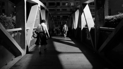 People walking on footbridge in city