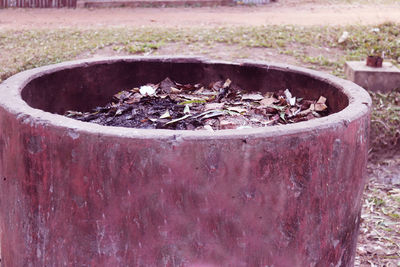 Close-up of old rusty metal container on field