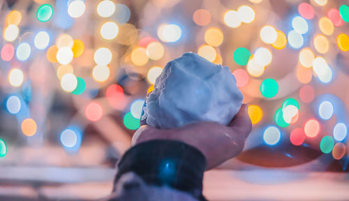 Close-up of hand holding snow at night