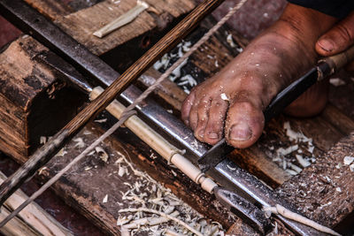 Low section of carpenter working on chisel