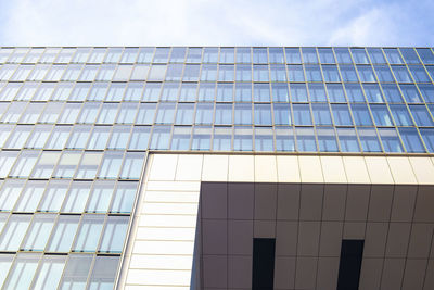 Low angle view of glass building against sky