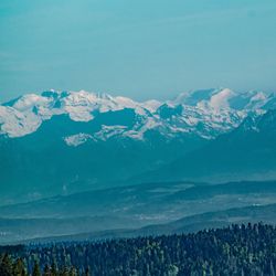 Scenic view of mountains against blue sky