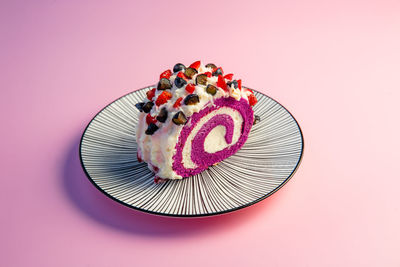 Directly above shot of dessert in plate against pink background