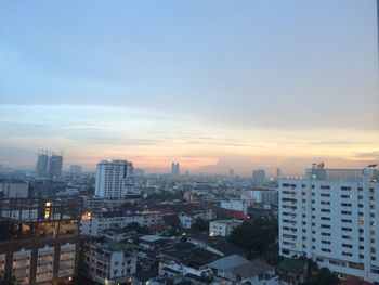 Aerial view of buildings in city against sky during sunset