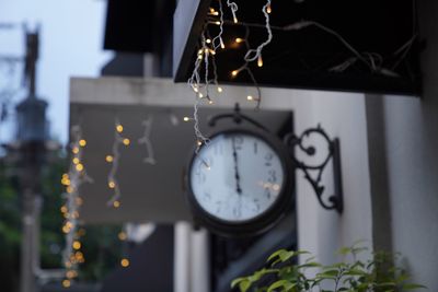 Low angle view of clock hanging on metal