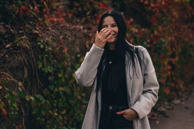 Full length of young woman standing on field during autumn