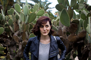 PORTRAIT OF SMILING YOUNG WOMAN IN PARK