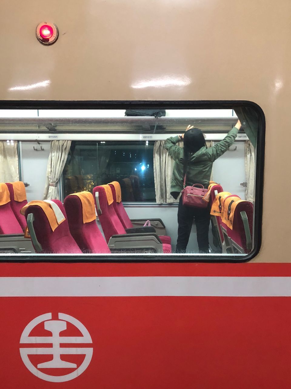 REAR VIEW OF WOMAN STANDING BY WINDOW