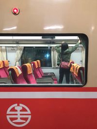 Rear view of woman standing in bus