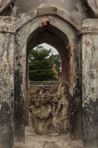 Old ruins against sky seen through arch