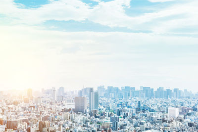 Aerial view of buildings in city against sky