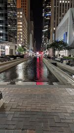 View of city street and buildings at night