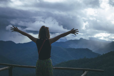 Rear view of woman looking at mountain range against sky