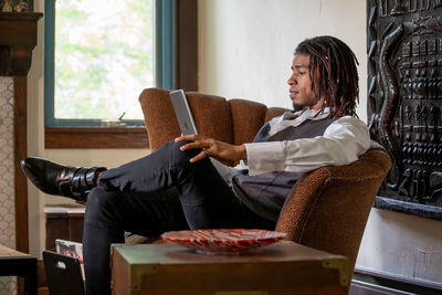 Young woman sitting on sofa at home