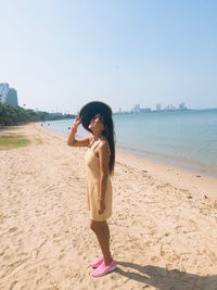 Woman standing on beach against sky