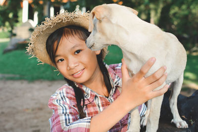 Close-up portrait of girl holding puppy at park