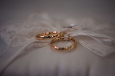 Close-up of wedding rings on bed