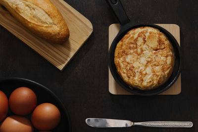 Spanish potato omelette shot from above in a dark still life picture.