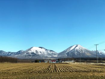 Scenic view of snowcapped mountains against clear blue sky