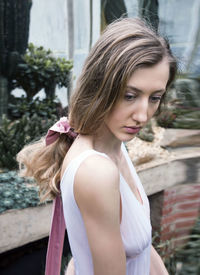 Side view of thoughtful young woman looking away while standing outdoors